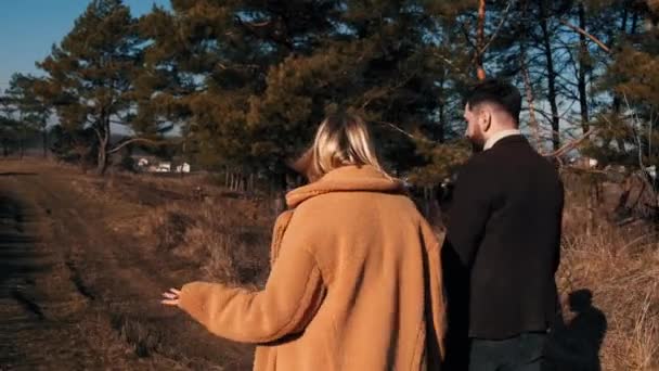 O casal amoroso está caminhando pelo caminho da floresta no outono — Vídeo de Stock