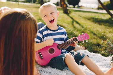 Anne ve oğlu yaz parkında oynuyorlar.
