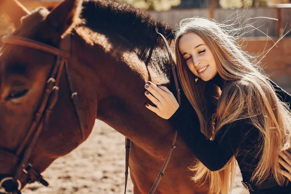Menina elegante com um cavalo em um rancho — Fotografia de Stock