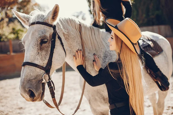 Eleganta flickor med en häst i en ranch — Stockfoto