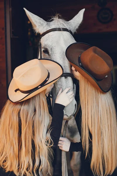 Meninas elegantes com um cavalo em um rancho — Fotografia de Stock