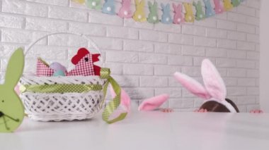 Bunny ears are showing at the table in an easter prepared kitchen