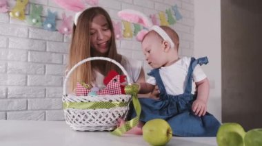 European mother with children are playing with easter eggs