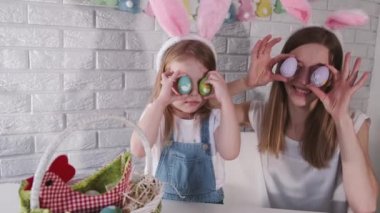 European mother with children are playing with easter eggs