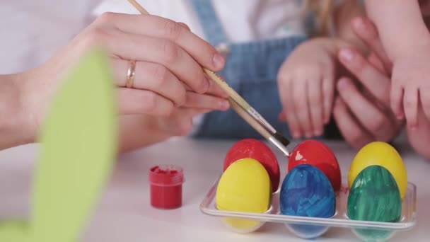 Velikonoční vajíčka jsou malována v různých barvách rukama — Stock video