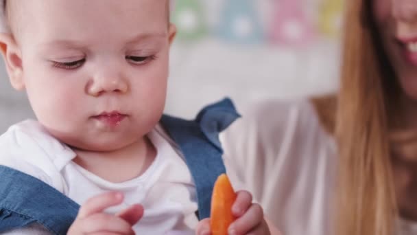 Un enfant joue avec un oeuf de Pâques avec sa mère à côté — Video