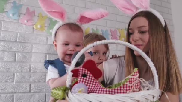 Европейская мать с детьми играет с пасхальными яйцами — стоковое видео