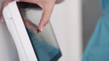 Cropped view of female hand touching screen in gym