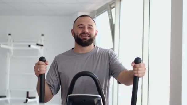 Uomo barbuto che utilizza spin bike nella stanza di fisioterapia — Video Stock