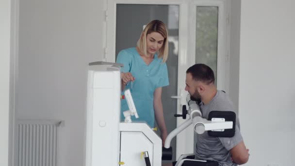 Paciente fazendo exercício usando equipamentos esportivos com terapeuta — Vídeo de Stock