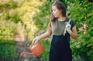 Güzel bir kadın evin yakınındaki bir bahçede çalışıyor.