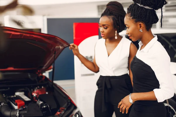 Dos mujeres negras con estilo en un salón de coches —  Fotos de Stock