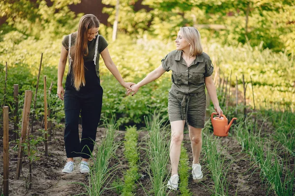 Schöne Frauen arbeiten in einem Garten in der Nähe des Hauses — Stockfoto