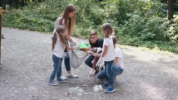 Gruppo di bambini in guanti che raccolgono la spazzatura nel parco cittadino — Video Stock