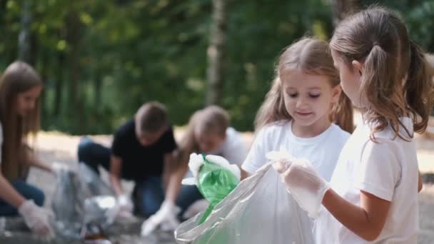 Gruppo di bambini con giovani volontari che raccolgono rifiuti nella foresta — Video Stock