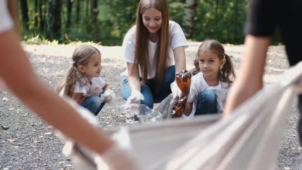 어린 자원 봉사자와 어린이들 이 숲 속에서 함께 쓰레기를 모은다 — 비디오