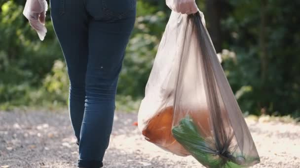 Persona sosteniendo bolsa con basura después de limpiar el bosque — Vídeo de stock
