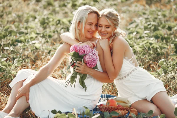 Mother with beautiful daughter in a autumn field