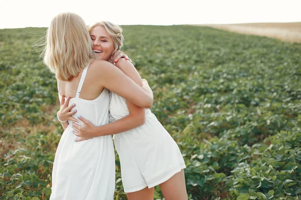 Mother with beautiful daughter in a autumn field — Stock Photo, Image