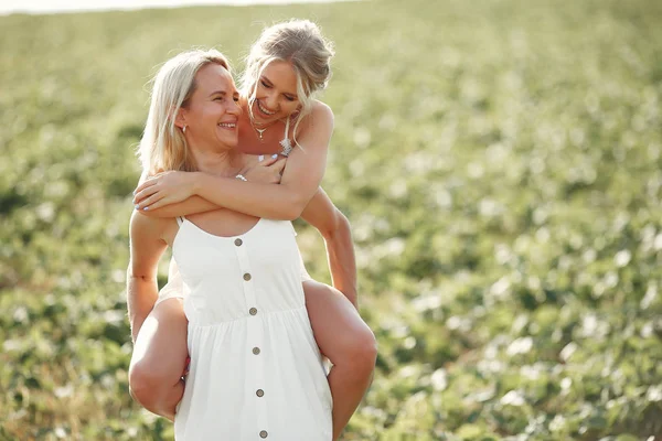 Mor med vacker dotter på ett höstfält — Stockfoto