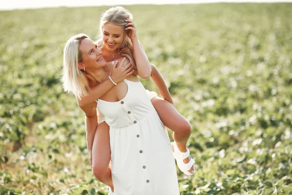 Mor med vacker dotter på ett höstfält — Stockfoto