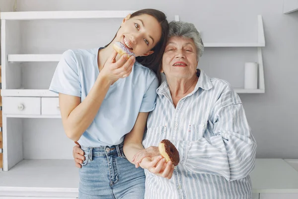 Стара жінка на кухні з молодою онучкою — стокове фото