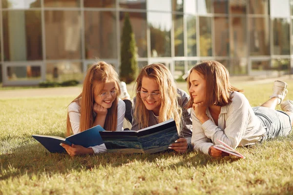 Trzech studentów leżących na trawie z książkami — Zdjęcie stockowe