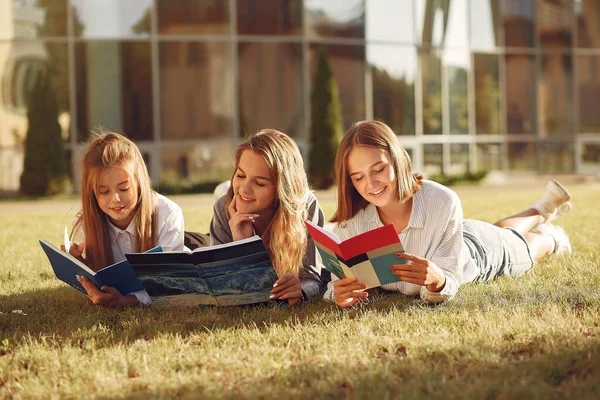 Trzech studentów leżących na trawie z książkami — Zdjęcie stockowe