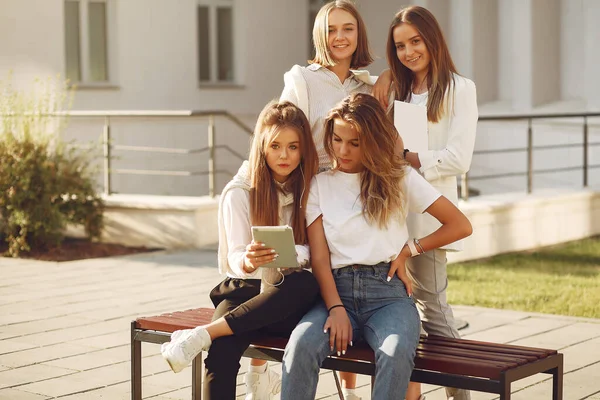 Four students on a student campus with a tablet — Stock Photo, Image