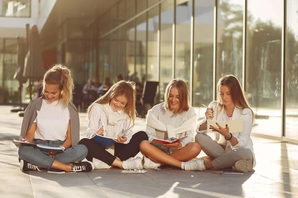 Quatre étudiants sur un campus étudiant avec une tablette — Photo