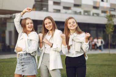 Öğrenci kampüsünde telefonlu genç öğrenciler.