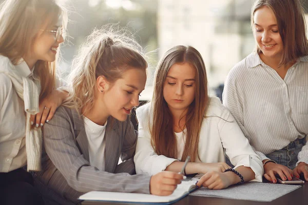 Czterech studentów na kampusie studenckim siedzących przy stole — Zdjęcie stockowe