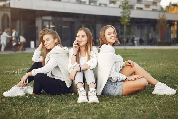 Jóvenes estudiantes en un campus de estudiantes con teléfono —  Fotos de Stock