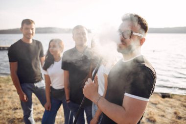 Gençler dışarıda nargile içerek pizza yiyor.