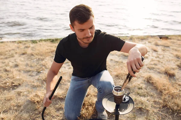 Bearded man fixing hookah for clients outside in summer — Stock Photo, Image