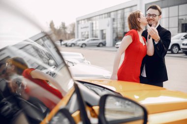 Bir araba galerisinde şık ve zarif bir çift.