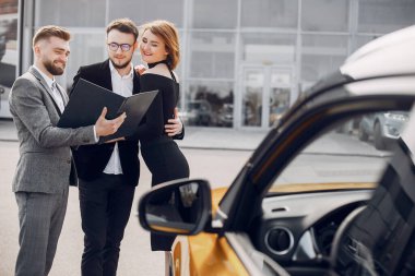 Bir araba galerisinde şık ve zarif bir çift.