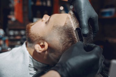 Berber dükkanında oturan şık bir adam.