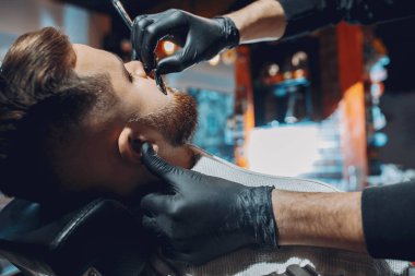 Berber dükkanında oturan şık bir adam.