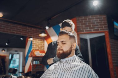 Berber dükkanında oturan şık bir adam.