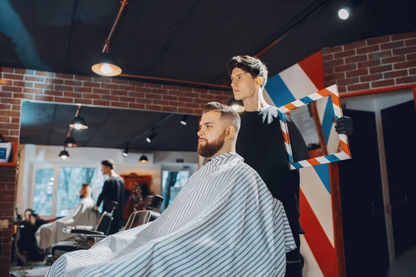 Elegante hombre sentado en una barbería — Foto de Stock