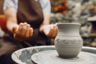 Torunları olan büyükanne çömlekçilikte sürahi yapar