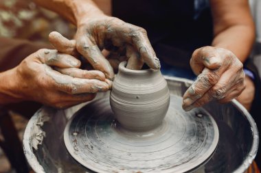 Torunları olan büyükanne çömlekçilikte sürahi yapar