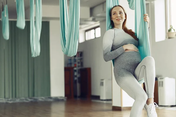 Mujer embarazada entrenando en un gimnasio — Foto de Stock