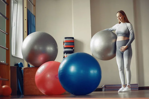 Беременная женщина тренируется в спортзале — стоковое фото