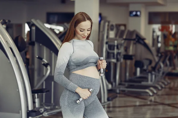 Mujer embarazada entrenando en un gimnasio —  Fotos de Stock