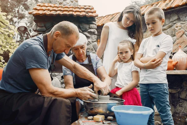 孫を持つ祖父母は陶器で水差しをする — ストック写真