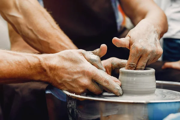 Torunları olan büyükanne çömlekçilikte sürahi yapar