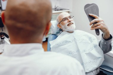 Eski diş hekimleri ofisinde oturan adam