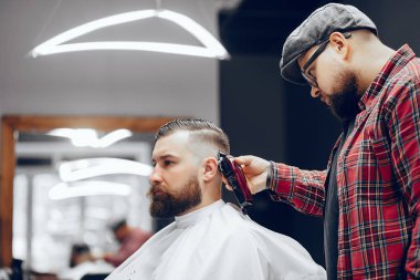 Berber dükkanında oturan şık bir adam.